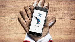 A smartphone with the Bosch tool app is lying on a glove.