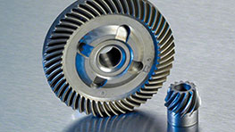 Gear and small gear made of metal on a silver background.