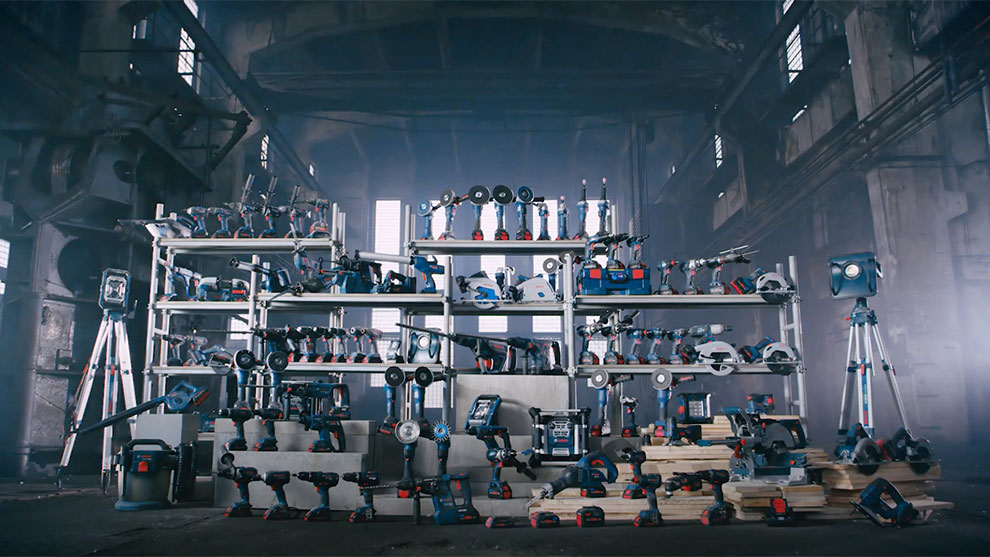 Diverse Bosch Professional tools on shelves in a workshop.