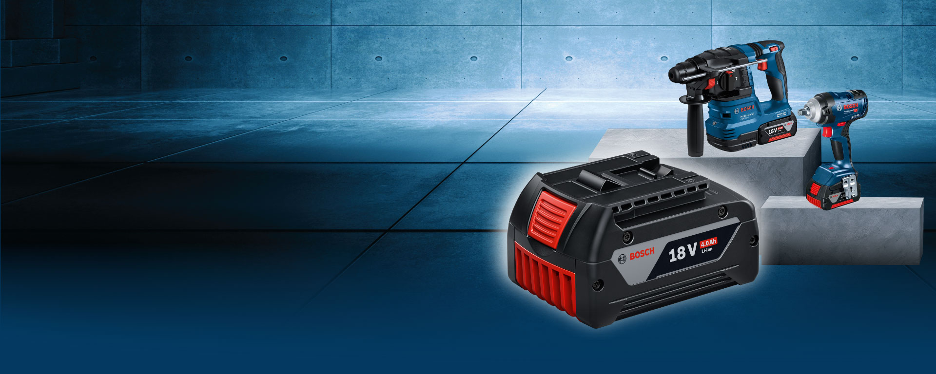 The image shows three Bosch tools on a gray concrete floor: a battery, a drill, and an impact wrench.