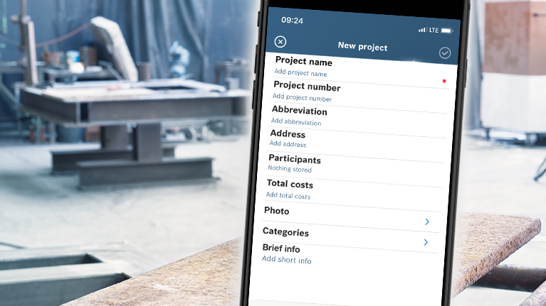 A smartphone displays project information in a workshop.