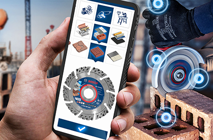 A smartphone with the Bosch Professional app shows various applications such as drilling and cutting. In the background, a workshop with tools and machines is visible.