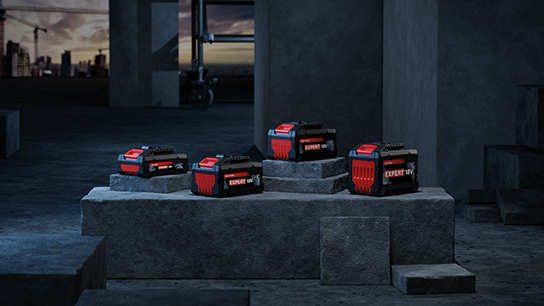 Benefits of 18V System Four Bosch Professional batteries are standing on gray concrete blocks.